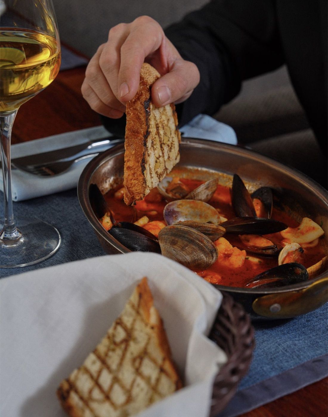 Kanarischer Meeresfrüchte-Eintopf mit Muscheln und Garnelen, dazu geröstetes Brot und ein Glas Weißwein