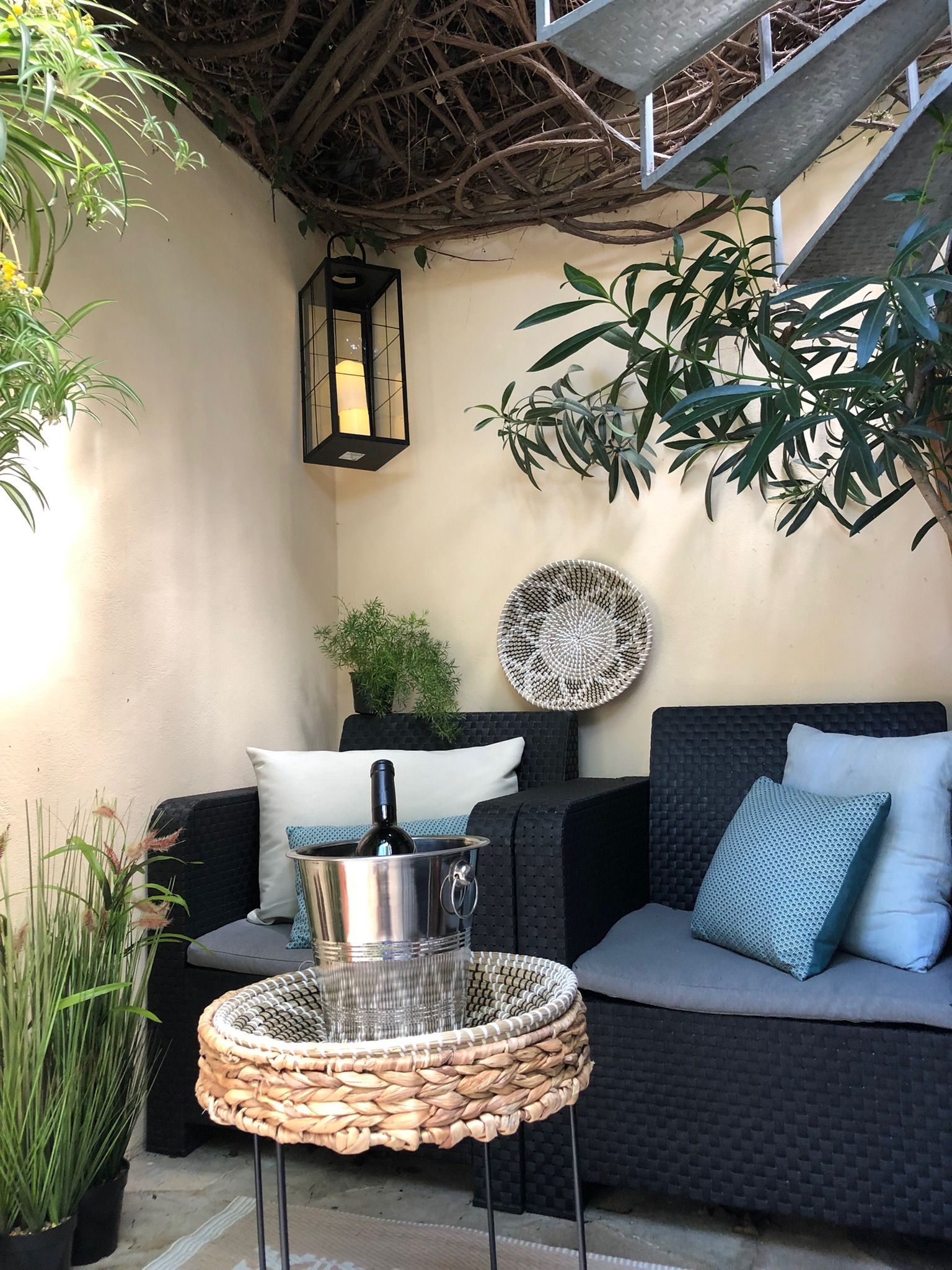 Casita Aquavista: Sitzecke im Patio mit Rattansofa, Laterne und Weinkühler unter der Wendeltreppe
