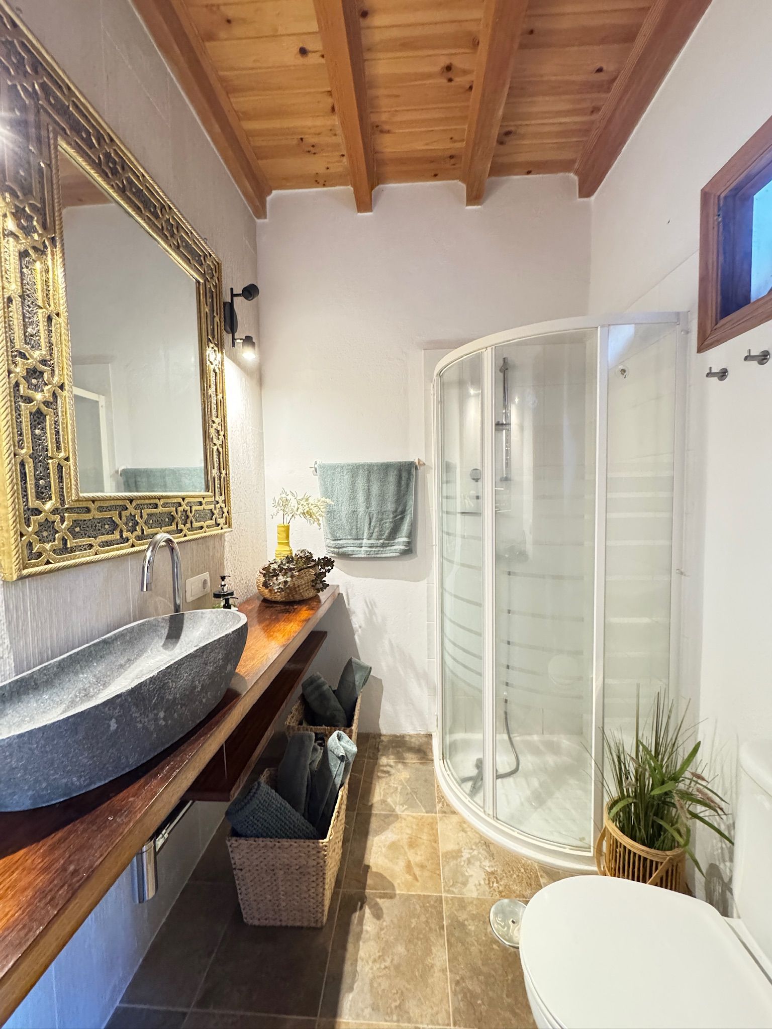 Casita Aquavista: Badezimmer mit Steinwaschbecken, verziertem Spiegel, Eckdusche und Holzdecke
