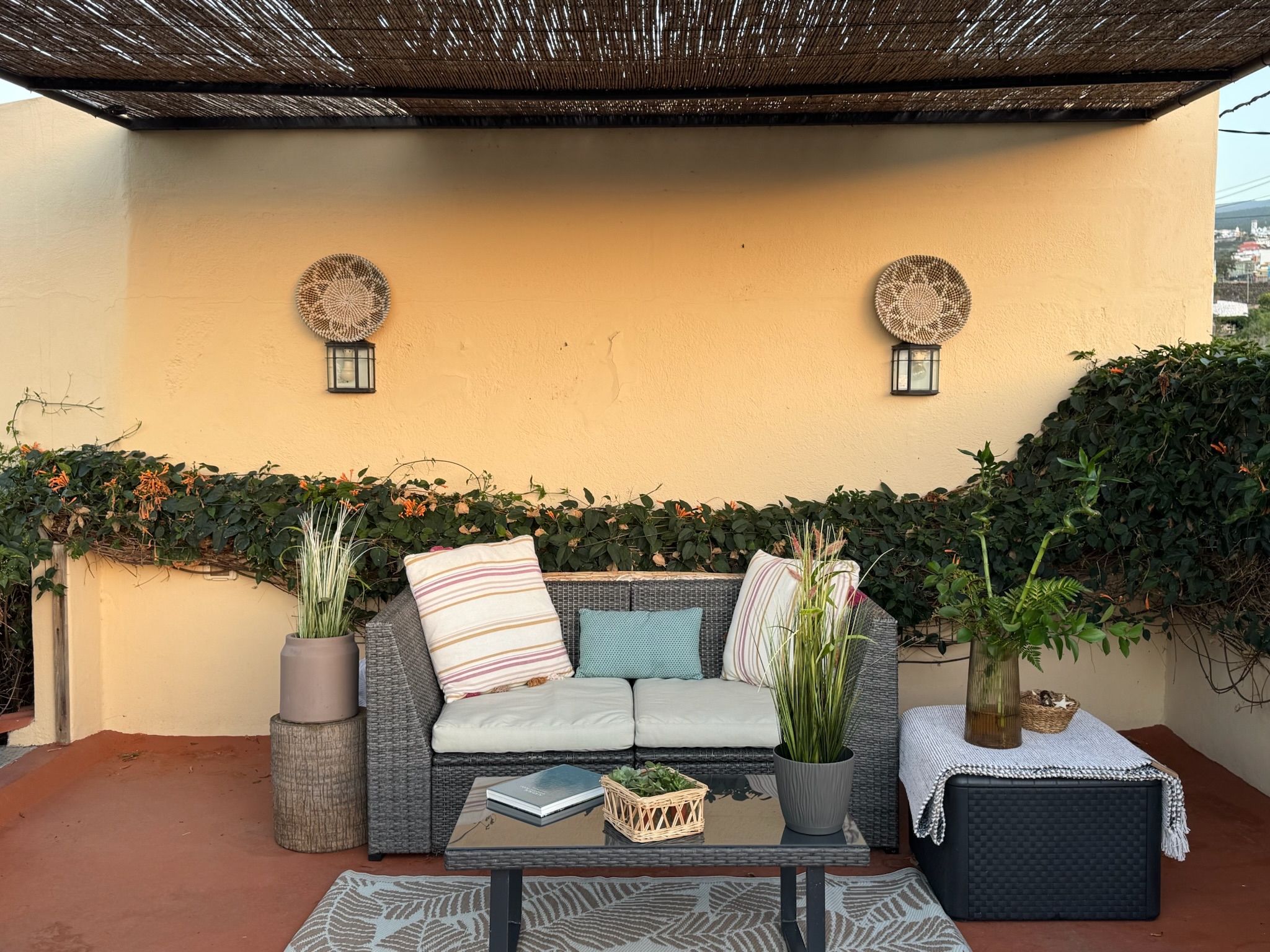 Casita Aquavista: Sitzecke auf der Dachterrasse mit Rattansofa und Couchtisch unter einem Sonnendach aus Schilf