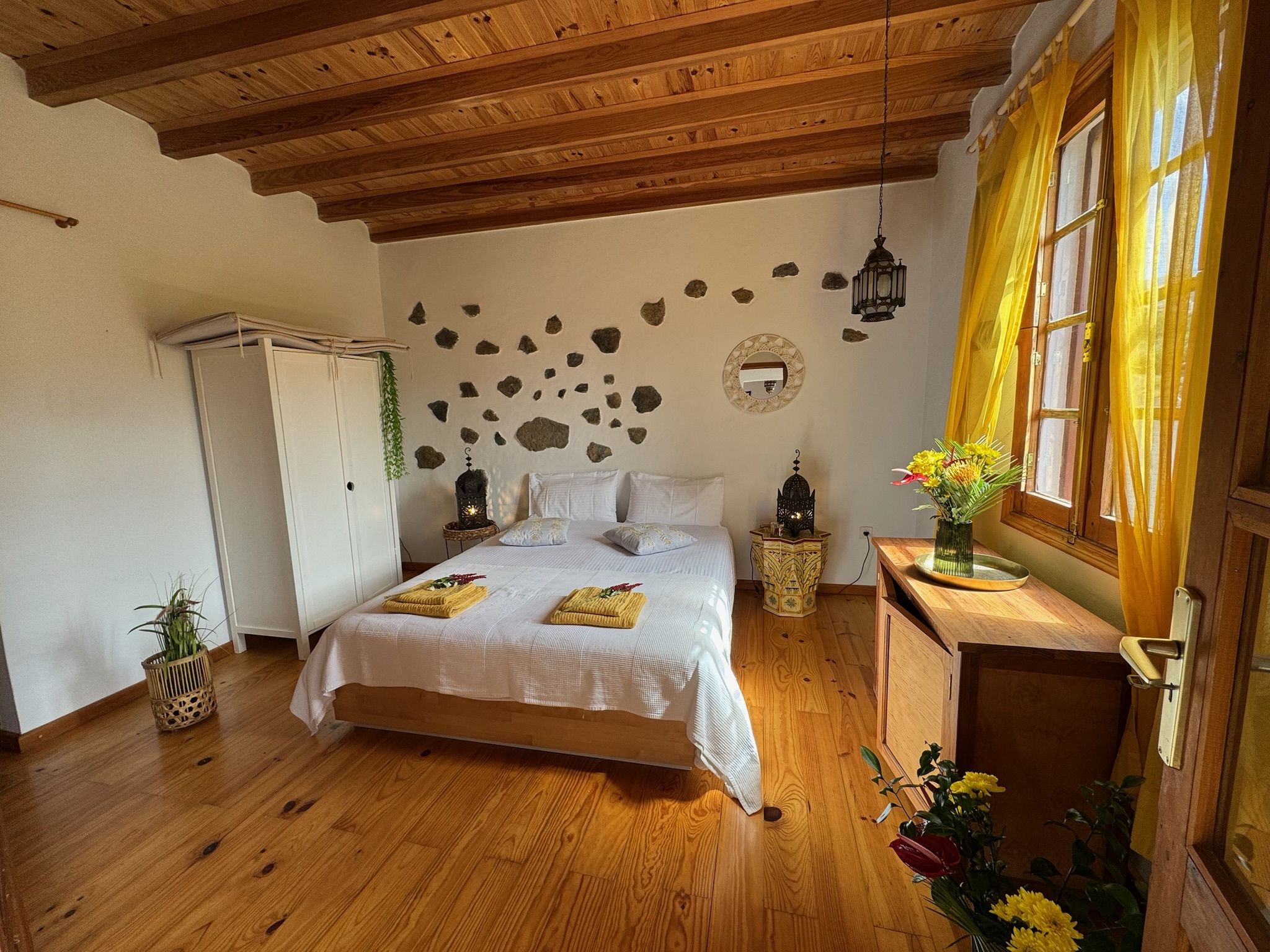 Casita Aquavista: Schlafzimmer mit Doppelbett, Holzbalkendecke, Natursteinen in der Wand und Kleiderschrank