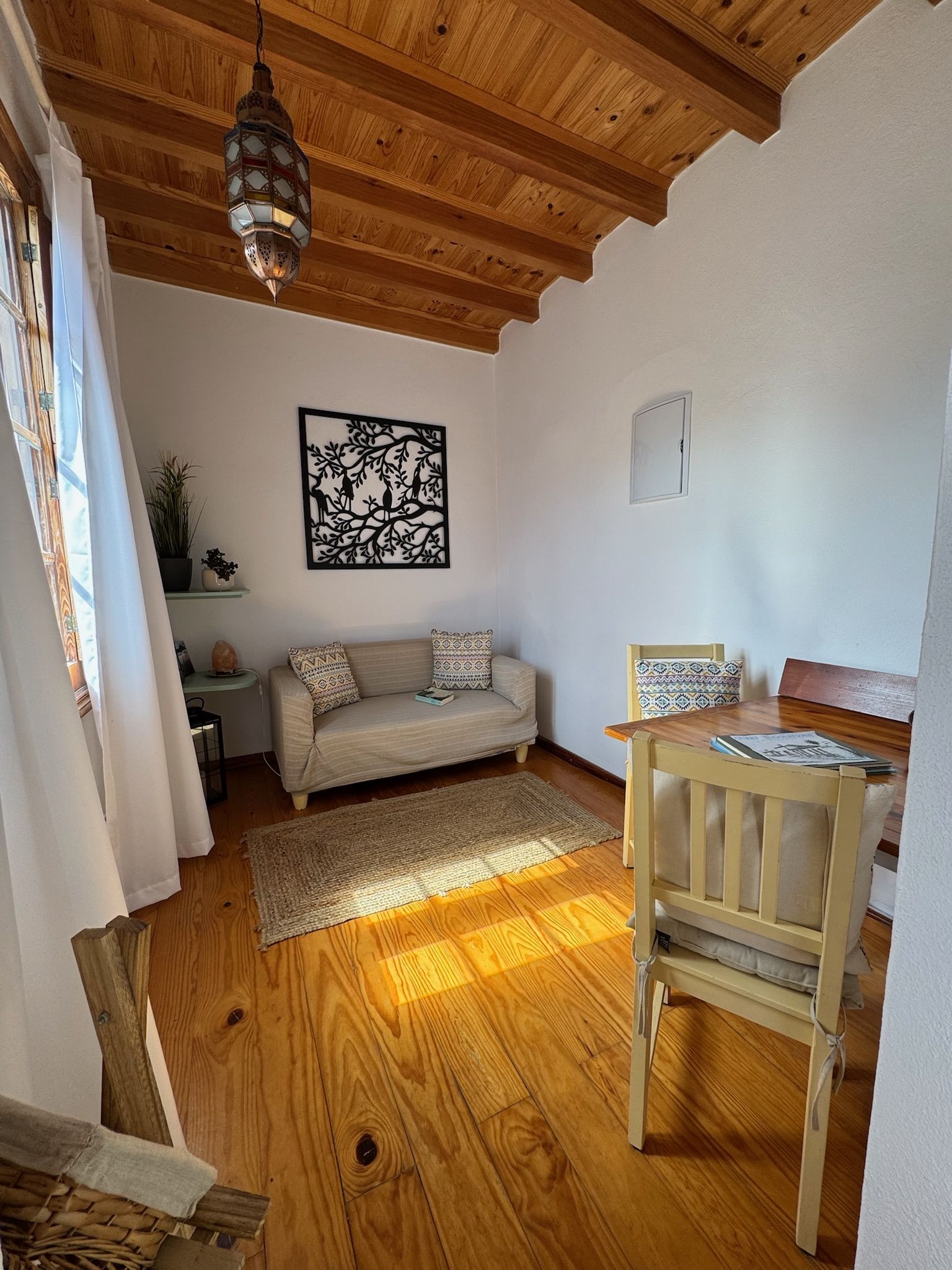 Casita Aquavista: Wohnraum mit Sofa, Esstisch mit zwei Stühlen, Holzboden und Holzbalkendecke