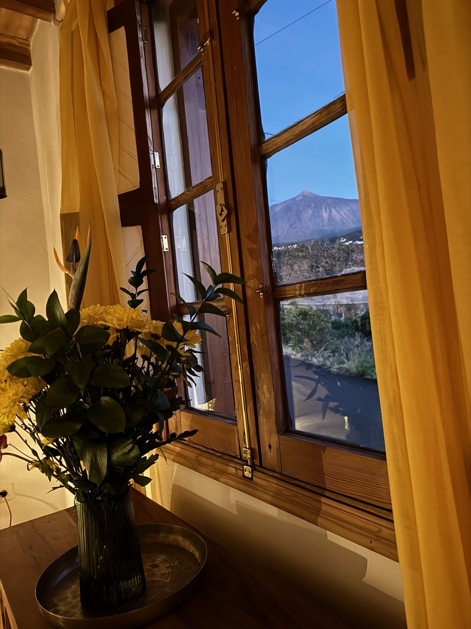 Casita Aquavista: Holzfenster im Schlafzimmer mit gelben Vorhängen und Blick auf den Teide in der Abenddämmerung